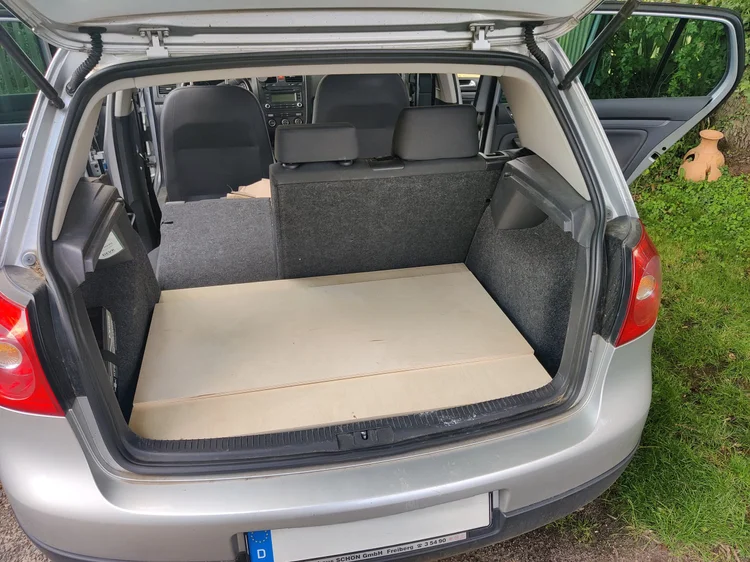 Die Rost Box aus Birkenholz kompakt im Kofferraum eines VW Golf Variant bei aufgestellten Rücksitzen
